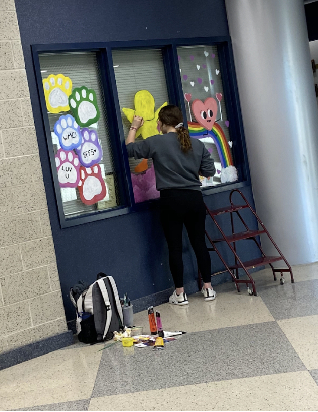 Makenna Lindsey paints the windows for Valentine’s Day.