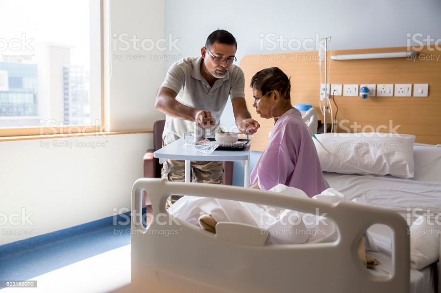 A doctor helps an elderly woman.