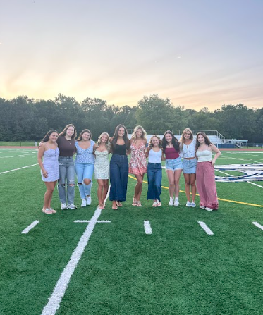 Left to Right: Seniors Violet Caruso, Quinn Commerford, Hannah Marney, Rylie Kaplan, Morgan Forlenza, Olivia Budd, Elyse Cuccaro, Abby Nasisi, Eliza Olsen, and Ella VanCoevering smile for a picture in front of the golden sunrise!