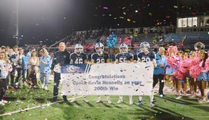 Photo of Coach Hennelly and captains surrounded in celebration for Coach Hennelly's 200th win.