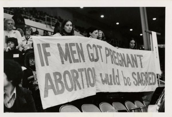 Photo of Women Holding Banner, "If Men Got Pregnant Abortion Would be Sacred" at the National Women's Conference 