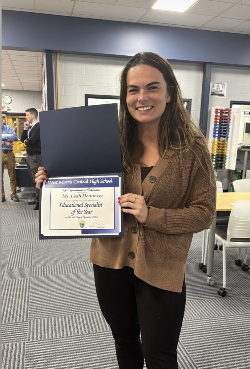 Ms. Hennessy is seen holding the award she earned. The big smile on her face shows how honored she is to have earned this title!