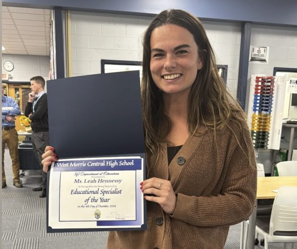 Ms. Hennessy is seen holding the award she earned. The big smile on her face shows how honored she is to have earned this title!