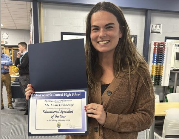 Ms. Hennessy is seen holding the award she earned. The big smile on her face shows how honored she is to have earned this title!