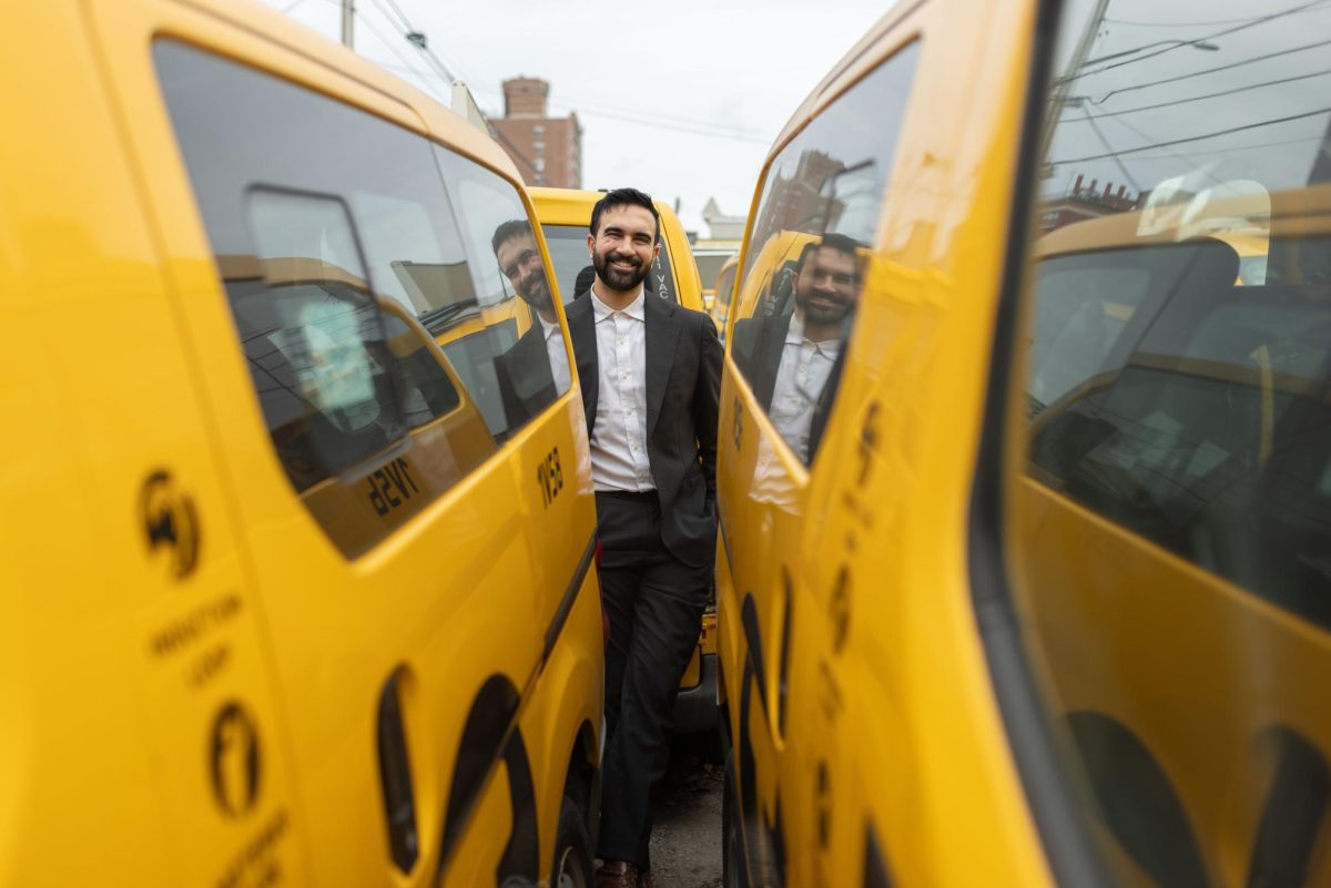 Zohran between yellow cabs, a symbol of NYC. 